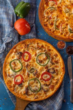 Çeşitli sebzeler ve baharatlarla dolu bir peynirli pizza.