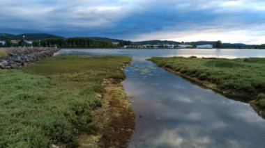 Colindres, Cantabria, İspanya 'daki Asn Nehri' nin ağzındaki bataklığın çok güzel bir zaman atlamalı videosu. Sahne, yemyeşil bataklıklar üzerinde su ve bulutların huzur dolu hareketlerini yakalar..