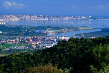 Tranquil Körfezi endüstriyel liman şehrinin yeşil ormanın ötesindeki ufuk çizgisini yansıtarak dinamik ve dinamik bir kontrastı oluşturur. Santander, Cantabria, İspanya, Avrupa.