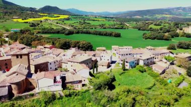Yeşil tarlalar ve ormanlarla çevrili, güneş ışığıyla yıkanmış resimli İspanyol köyü. Iguzkiza, Navarre, İspanya. İHA görüntüsü. Yüksek kalite 4k görüntü