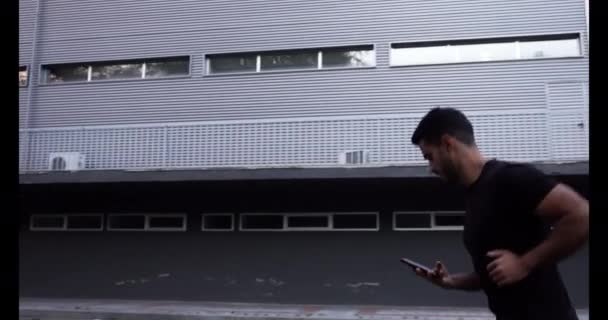 Man Met Gespierde Benen Gekleed Zwarte Trainingskleding Rent Weg Terwijl — Stockvideo