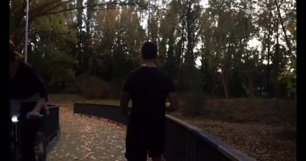 작업복을 근육질의 다리를 도시의한 다리를 건너고 가을이 떨어진다 — 비디오