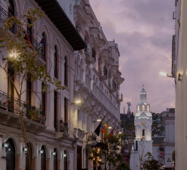 Quito Metropolitan Katedrali 'nin çan kulesinin gece görüşü. Arka planda, çöreğin içindeki Bakire Legarda.