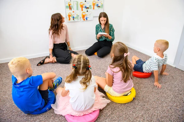 Child occupational therapy background. Elementary age children in group therapy. Teacher and pupils in class.