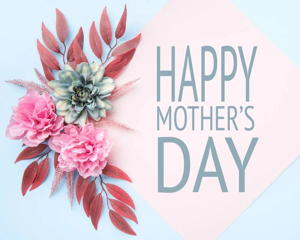 Happy Mother\'s Day Pastel Blue and Pink Colored Background. Flat lay floral greeting card with beautiful silk flowers.