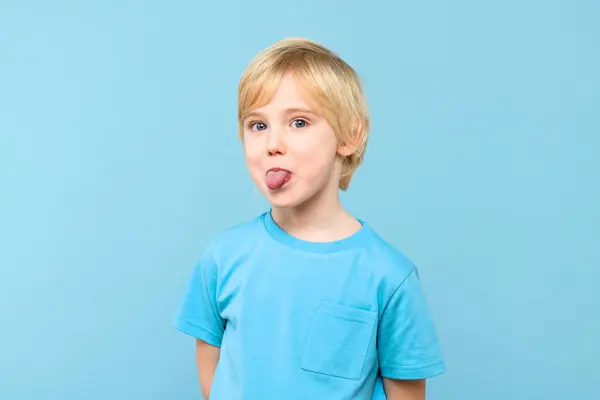 Funny Young Boy Showing Tongue Looking Camera Pastel Blue Background — Stock Photo, Image