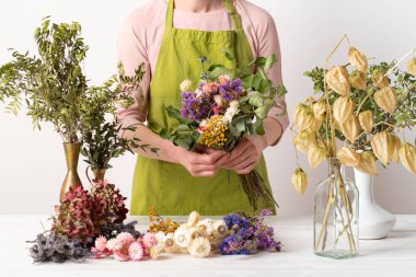 Kurumuş çiçekler. Dişi çiçekçi kurumuş çiçekleri güzel bir bukete yerleştiriyor. Sürdürülebilir çiçekçilik. Kurumuş çiçeklerle ev dekorasyonu oluşturuluyor.