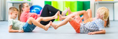 Küçük çocuklar grup terapisi sırasında fizyoterapistle egzersiz yapıyorlar. Çocuk mesleği fizyoterapisi. Çift taraflı koordinasyon.