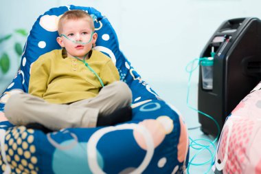 Oksijen terapisi, ayrıca ek oksijen olarak da bilinir. Solunum problemleri olan genç bir çocuk burun kanülü yoluyla oksijen solunum cihazına bağlı..