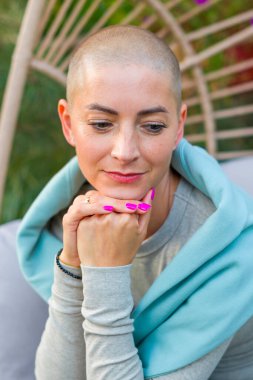 Bahçe bahçesinde oturan genç bir kanser hastası sallanan bir sandalyede sallanıyor. Akıl sağlığı, refah, yaşam dengesi, hastalık sırasında meditasyon..