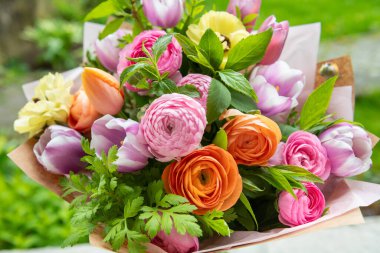 Bahar buketi. Çok güzel renkli taze çiçek aranjmanı. Lalelerden ve açık havada çekilen ranuncululardan yapılmış doğum günü buketi.. 