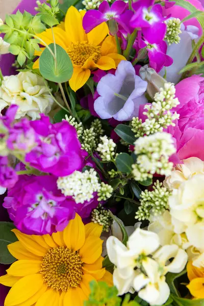 Karışık bahar çiçeklerinden yapılmış çiçek buketi. Güzel canlı renkli taze çiçekler düzenlemesi. Şakayık ve ayçiçekli doğum günü buketi.