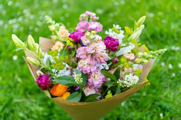 Karışık bahar çiçeklerinden yapılmış çiçek buketi. Güzel canlı renkli taze çiçekler düzenlemesi. Aslanağzı, şakayık ve matthiola stoklu doğum günü buketi.