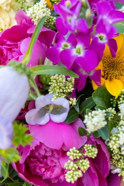 Karışık bahar çiçeklerinden yapılmış çiçek buketi. Güzel canlı renkli taze çiçekler düzenlemesi. Şakayık ve ayçiçekli doğum günü buketi.