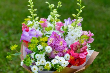 Karışık bahar çiçeklerinden yapılmış çiçek buketi. Güzel pastel renkli taze çiçek aranjmanı. Aslanağzı, matthiola ve Canterbury çanları olan bir buket doğum günü..