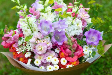 Karışık bahar çiçeklerinden yapılmış çiçek buketi. Güzel pastel renkli taze çiçek aranjmanı. Aslanağzı, matthiola ve Canterbury çanları olan bir buket doğum günü..