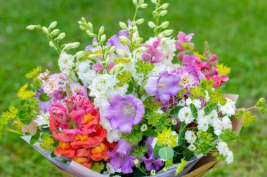 Karışık bahar çiçeklerinden yapılmış çiçek buketi. Güzel pastel renkli taze çiçek aranjmanı. Aslanağzı, matthiola ve Canterbury çanları olan bir buket doğum günü..