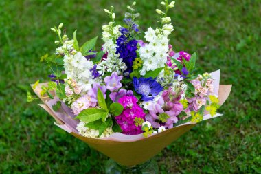 Karışık bahar çiçeklerinden yapılmış çiçek buketi. Güzel pembe, beyaz ve mavi çiçek aranjmanı. Larkspur ve Matthiola stoklu doğum günü buketi.