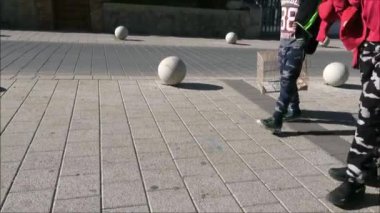 Alora, Spain - January 27, 2019: Two teenage boys walking with empty birdcages in winter sunshine in Andalusian village
