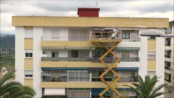 Alora スペイン 2019年1月31日 アンダルシアの村の冬の日差しの中でアパートを修復する拡張モバイルプラットフォーム上で作業する男 — ストック動画