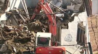 Alora, İspanya - 17 Temmuz 2019: Kazıcı Endülüs köyündeki yıkılmış evdeki yıkıntıları temizliyor. Kazıcı yıkılmış evdeki molozları kaldırıyor