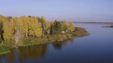 Sonbaharda renkli ormanlarla çevrili güzel gölün hava görüntüleri.