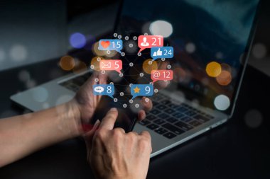 Social media notification icons are used in this concept. A businessman's hands are holding a device. Interactions on social media via mobile phone, internet digital marketing online community.