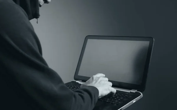 不正利用者によるサイバー犯罪標的のウェブサイトに侵入するためにノートパソコンを使用しています — ストック写真