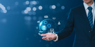 Bir işadamı dünyayı çeşitli iş simgelerini, küresel büyük verileri ve internet bağlantısı uygulamalarını gösterirken gösteriyor. Finansal, bankacılık kavramlarının yanı sıra dijital pazarlama, bağlantı teknolojileri.