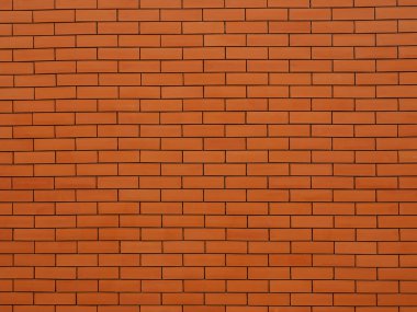 Turuncu renkli tuğla duvar, yakın görüntüleri yakalar. Tuğla işçiliğindeki derin yarıklar görünür..