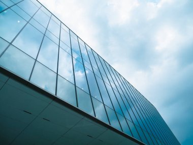 Bulutlu mavi gökyüzü arkaplanı olan cam binalar