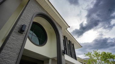 Yağmur yağmaya hazır gibi görünen karanlık ve temiz bir gökyüzü modern evi çerçeveliyor..