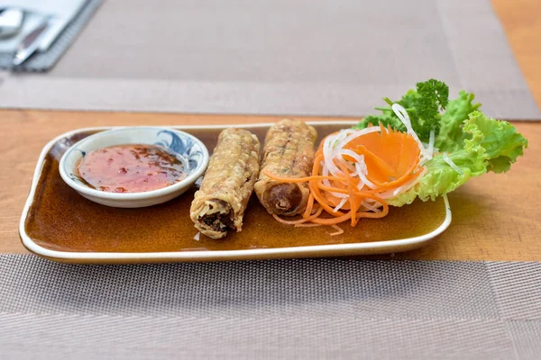 Spring rolls served with salad and souse