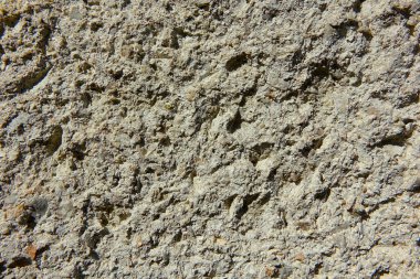 Doğal ışıkla aydınlatılmış kaba alçı bir duvarın ayrıntılı dokusu.