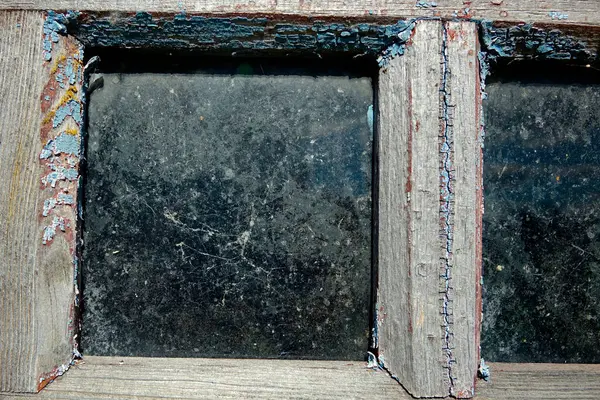 Eski ahşap ve tozlu camlı kırsal ahır penceresinin detaylı görüntüsü.