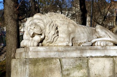 Uyuyan aslan heykeli, Lviv 'deki tarihi Toz Kulesi' nin yanında, ağaçlarla çevrili, huzur içinde yatıyor..