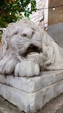 Uyuyan bir aslanın güzel detaylı heykeli Lviv 'deki tarihi Toz Kulesi' nin yanında huzur içinde yatıyor..