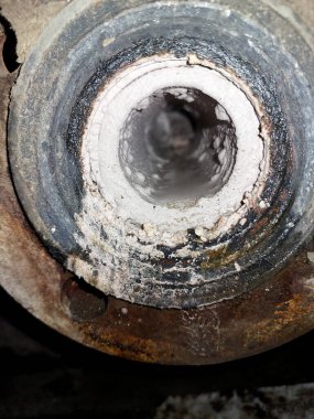 Bir borunun iç yüzeyine yakından bakınca önemli kireçtaşı birikintileri ortaya çıkıyor ve endüstriyel bir ortamda potansiyel bakım endişelerini vurguluyor..