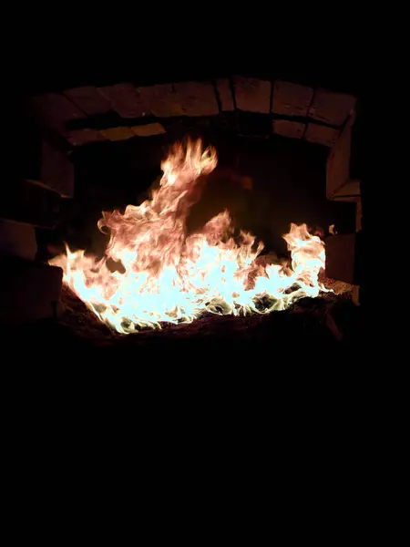 Biyoyakıt yanma alevleri bir buhar kazanının içinde, ısı jeneratörünün kırıcı tuğla kaplamasını gösteriyor..