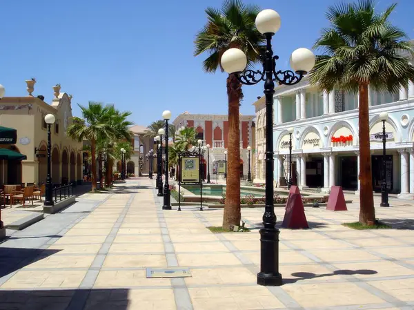 stock image Visitors stroll along a lively promenade in a resort town, enjoying the warm sun