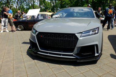Lviv, Ukrayna - 1 Haziran 2023 Pürüzsüz, gri Audi TT RS spor arabası parkta canlı bir otomotiv toplantısında sergileniyor. Hevesli katılımcılar çeşitli klasiklere hayran.