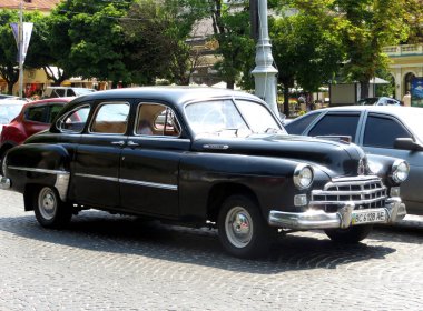 Lviv, Ukrayna - 22 Haziran 2013 Klasik bir siyah GAZ-12 ZIM klasik araba işlek bir şehir caddesi boyunca park edilmiştir. Güneş batıyor, arabanın detaylarını ve çevre kentsel manzarayı vurguluyor.