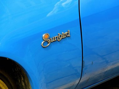 Lviv, Ukrayna - 14 Haziran 2015 Bu canlı mavi araba üzerinde parlak bir Pontiac Sunbird amblemi barındırıyor 1978 model klasik otomotiv tasarımı temiz bir bitiş ve biraz aşınmayla, güneş ışığını güzel yansıtıyor..