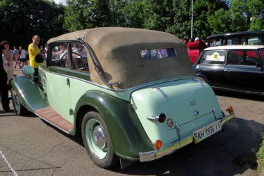 Lviv, Ukrayna - 5 Haziran 2016 Üstü açık yeşil bir AUDI 225 1936 üstü açık, bej renkli, ağaçlarla çevrili bir parkta klasik bir araba etkinliğinde sergileniyor.