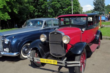 Lviv, Ukrayna - 5 Haziran 2016 ForD Phaeton 1928 model güzel restore edilmiş klasik bir araba yerel bir açık hava etkinliğinde ağaçların ve diğer klasik araçların arasında cazibesini sergiliyor.