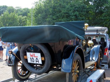 Lviv, Ukrayna - 5 Haziran 2016 ForD TaXI adlı klasik bir klasik klasik klasik araba, siyah dış ve yeşil kapaklı bir araç bir servis aracının yanında çekiliyor. İnsanlar, bereketli ağaçların sağladığı araca hayran.