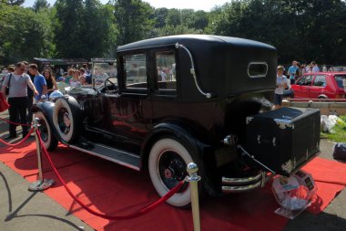 Lviv, Ukrayna - 5 Haziran 2016 Packard 1930 model klasik bir araba, açık mavi gökyüzü altında klasik tasarımına hayran olan seyircilerin izlediği bir kırmızı halıda dikkat çekiyor.