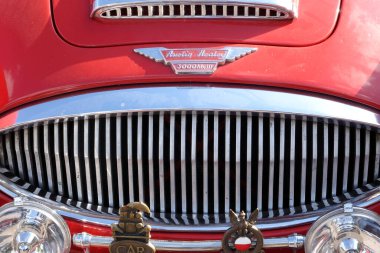 Lviv, Ukrayna - 6 Haziran 2017 Eski model kırmızı bir araba Austin-Healey 3000 MKIII güneş ışığında parıldıyor, krom aksanını ve karmaşık tasarım elementlerini vurguluyor.