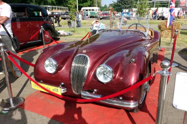 Lviv, Ukrayna - 6 Haziran 2017 çarpan kırmızı spor araba Jaguar XK120, ziyaretçiler ve diğer klasik arabalarla çevrili klasik bir araç sergisinde sergileniyor..