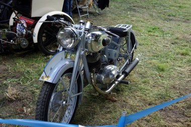 Lviv, Ukrayna - 6 Haziran 2017 Klasik bir klasik motosiklet Victoria açık hava etkinliğinde çimlerin üzerine park edilmiş, parlak krom detaylarını, eşsiz tasarımını, klasik araçlarını ve yeşilliklerini sergiliyor..